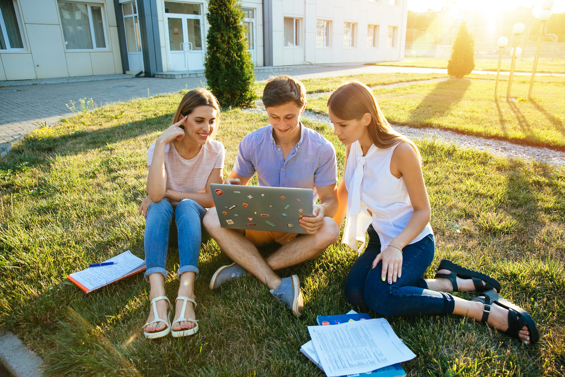 Group of teenage students studying together with a laptop