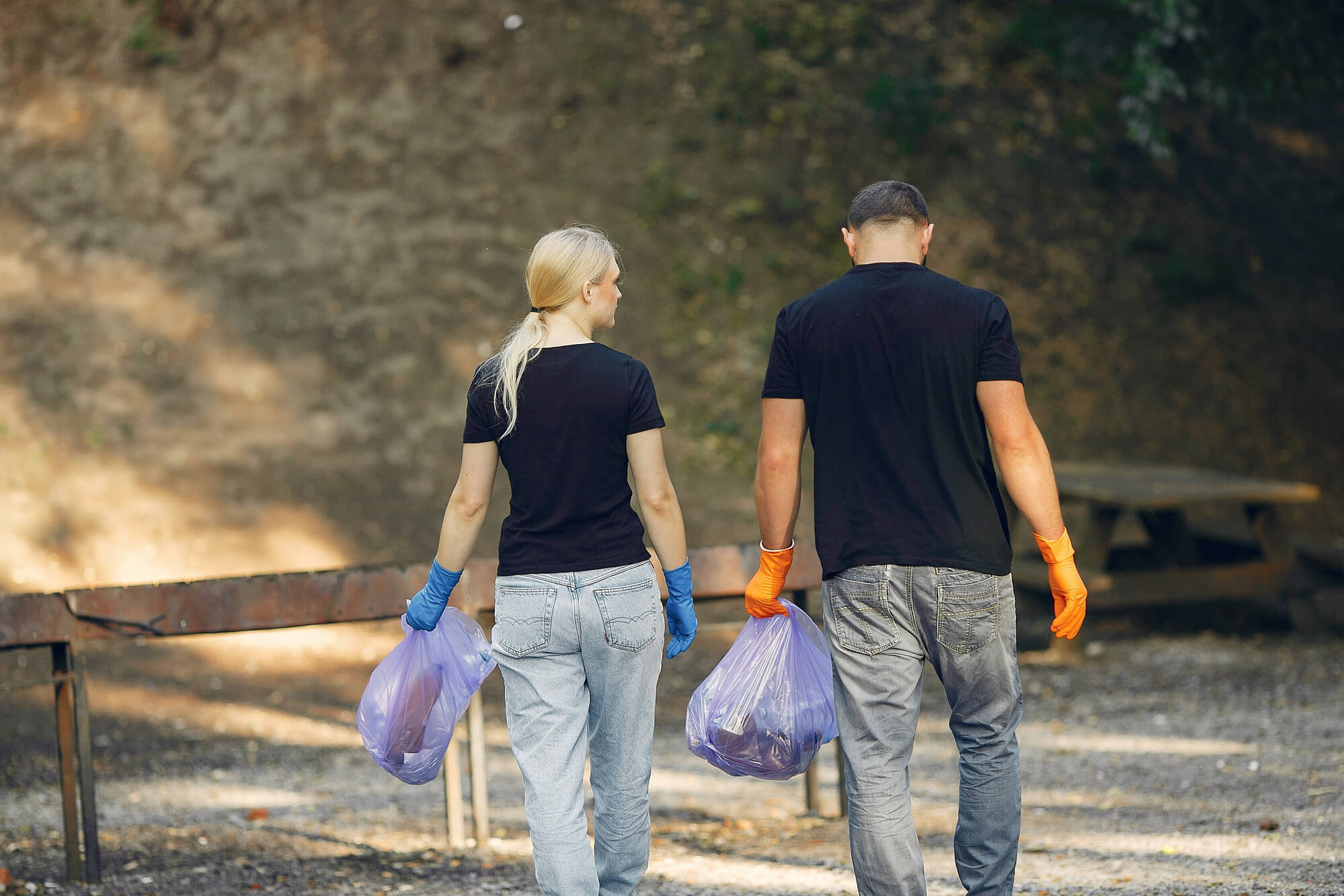 Couple collecting garbage into bags during a park clean-up