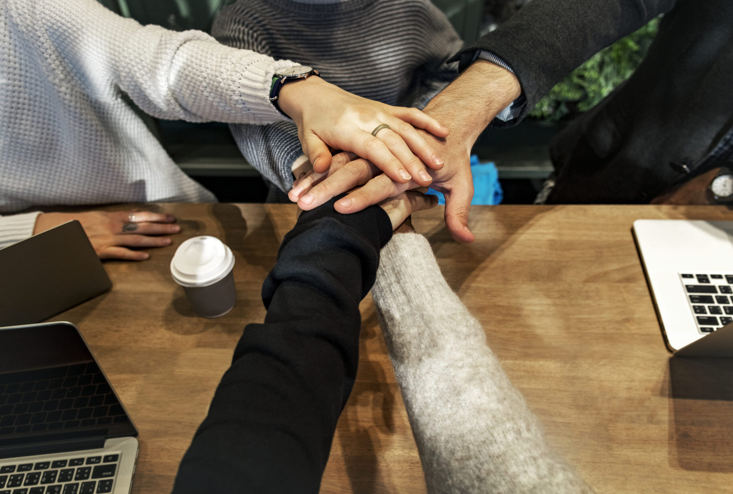 Diverse group of people stacking their hands together in solidarity