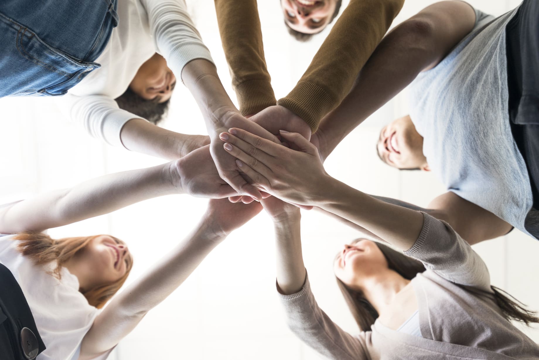 Group of young people holding hands together in a circle